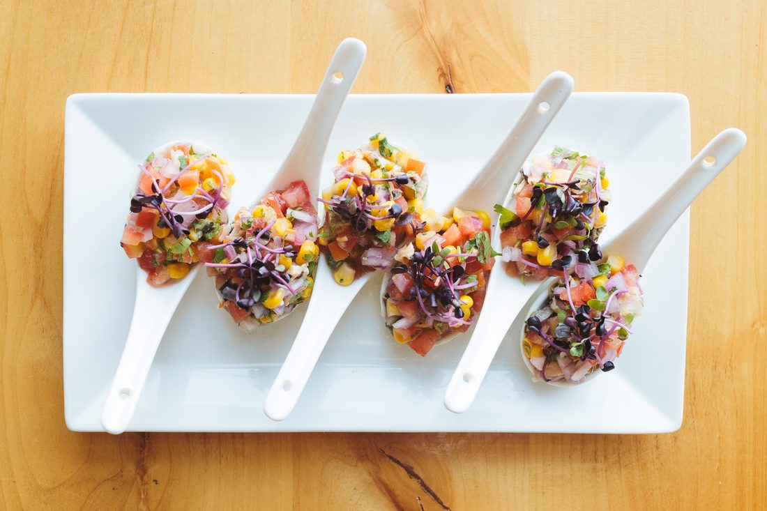 Ceviche — fresh fish cured in leche de tigre with corn and red onion.