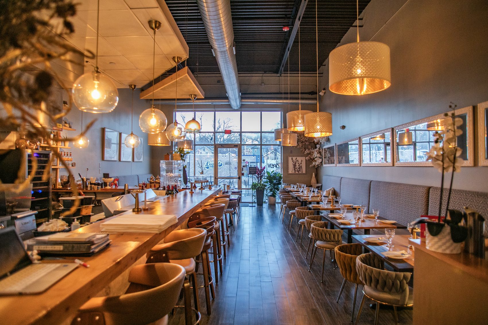 Panka's warm dining room with blush velvet chairs, warm wood tables and pendant lighting.